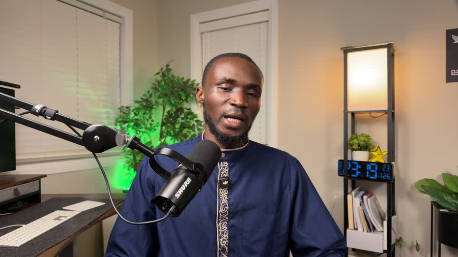 Jatto speaking into a microphone at his desk